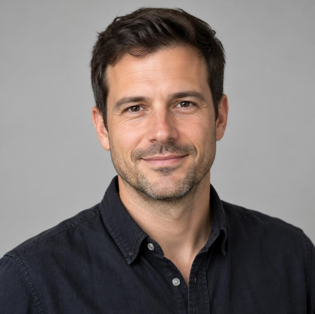 Portrait of a man with short dark hair and a light stubble beard